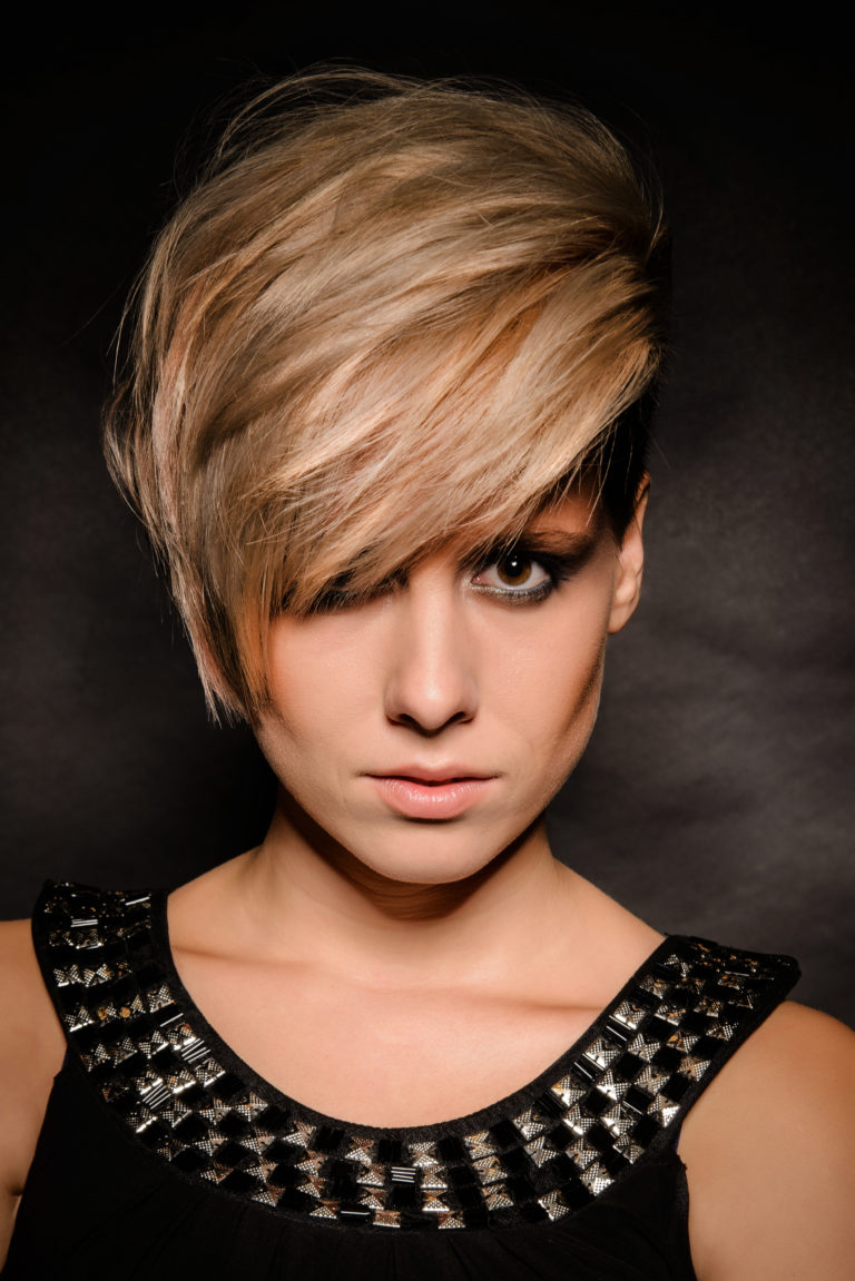 Blonde girl with a short stylish haircut on a dark background
