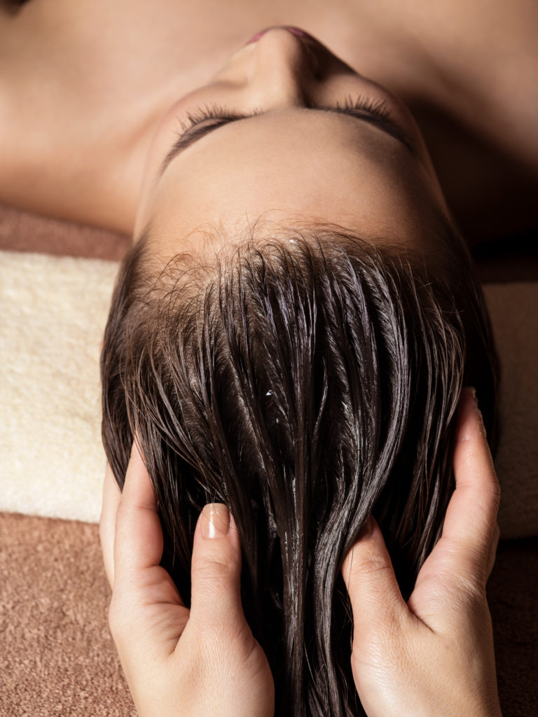 Cosmetologist massaging hair on the head of the woman. Spa treatments. Beauty treatment. Spa salon